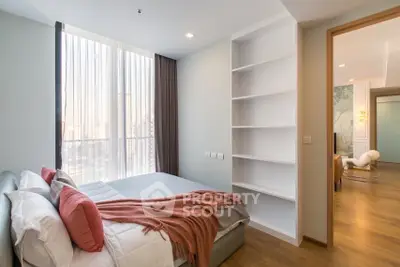 Modern bedroom with cozy decor and large window offering city view