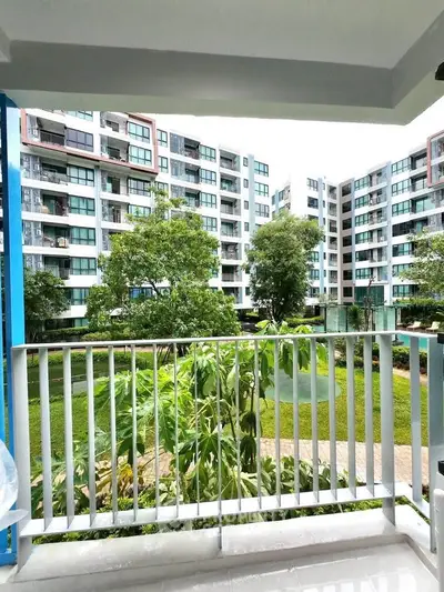 Modern apartment balcony with lush garden view in urban setting