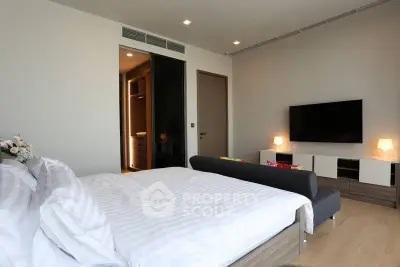 Modern bedroom with stylish decor and large TV, perfect for relaxation.