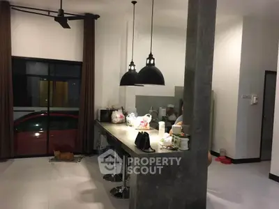 Modern kitchen with concrete island and pendant lighting in stylish home