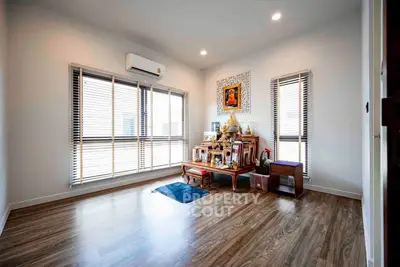 Spacious living room with wooden flooring and large windows for natural light