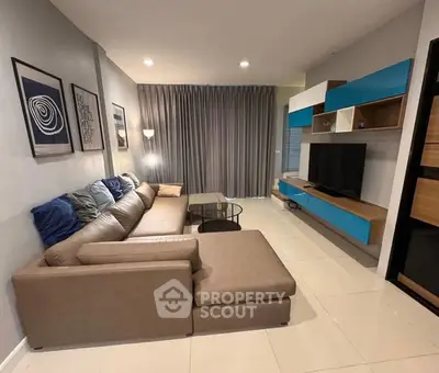 Modern living room with stylish sectional sofa and wall-mounted entertainment unit.