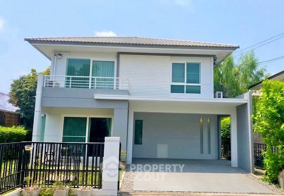 Modern two-story house with balcony and spacious driveway in a serene neighborhood.