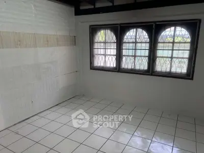 Spacious room with tiled floor and large windows, ideal for customization.