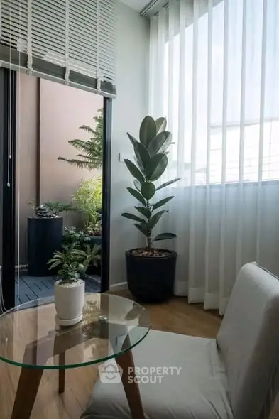 Cozy corner with glass table and plants in modern apartment