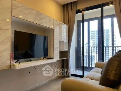 Modern living room with sleek TV setup and balcony view in urban apartment.