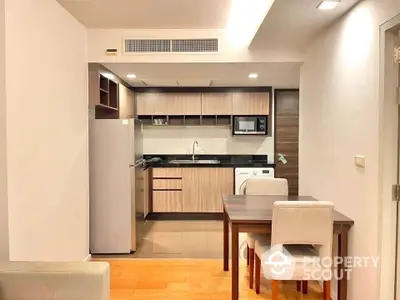 Modern kitchen with dining area in a stylish apartment featuring sleek cabinetry and appliances.