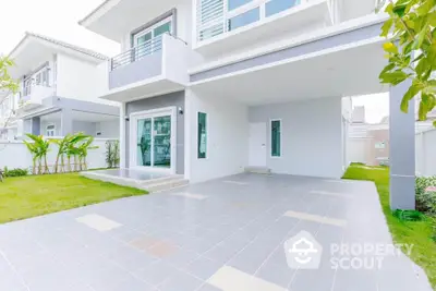 Modern two-story house with spacious driveway and lush green lawn