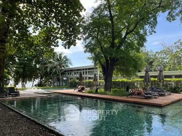 Luxurious outdoor pool area with lush greenery and modern architecture, perfect for relaxation and leisure.