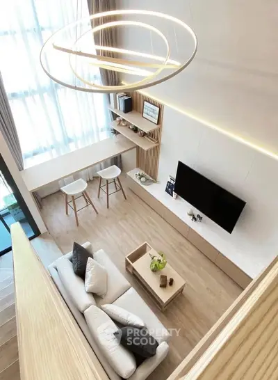 Modern living room with high ceiling, stylish lighting, and minimalist decor