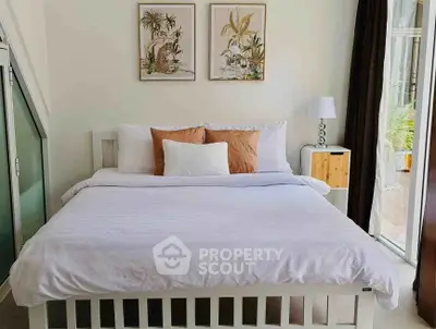 Cozy bedroom with stylish decor and natural light, featuring a comfortable bed and elegant artwork.