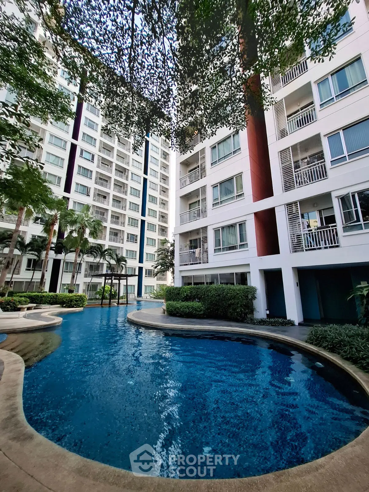 Modern residential building with stunning pool and lush greenery