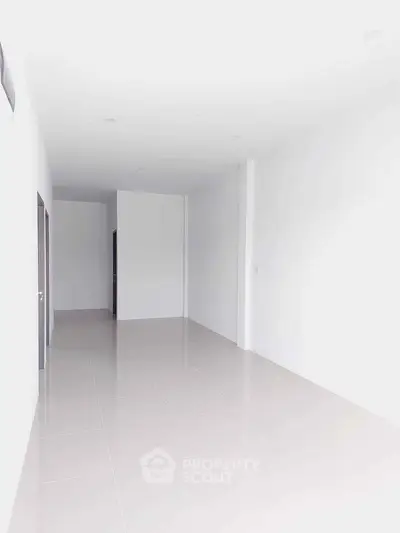 Spacious empty room with white walls and tiled floor, ideal for customization.