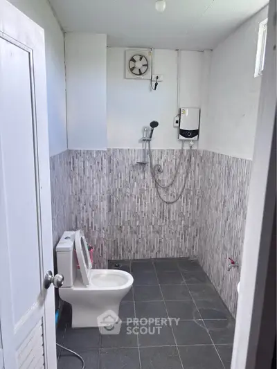 Modern bathroom with sleek tile design and essential fixtures in a real estate property.