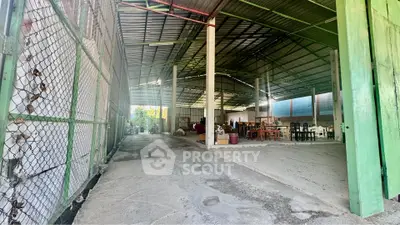 Spacious industrial warehouse with high ceilings and open layout, ideal for storage or manufacturing.