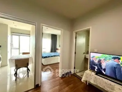 Modern apartment interior with bedroom, dining area, and TV setup, showcasing bright and cozy living space.