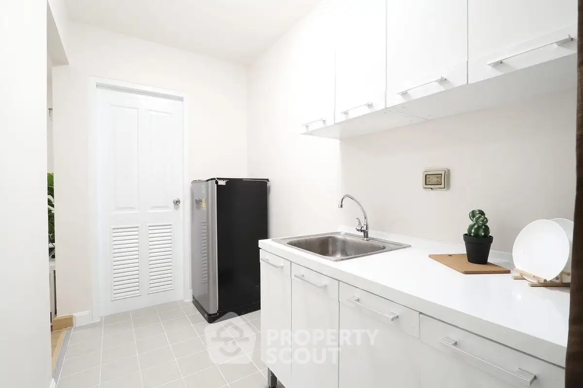 Modern kitchen with sleek white cabinets and stainless steel sink