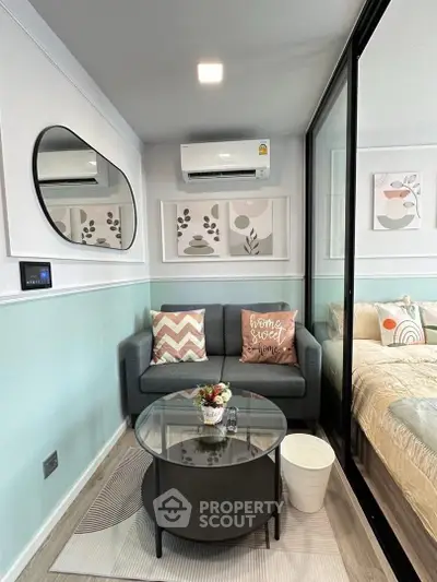 Chic modern living room with cozy sofa, stylish decor, and glass partition leading to bedroom.