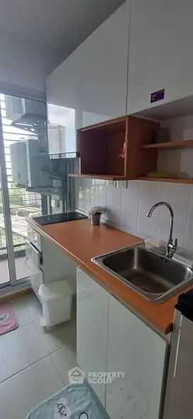Modern kitchen with sleek cabinetry and balcony view