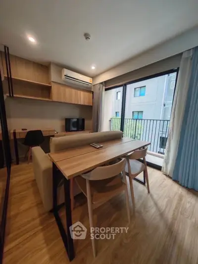 Modern living room with wooden flooring, cozy sofa, and balcony view in a stylish apartment.