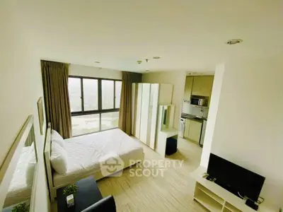 Modern studio apartment with panoramic city view and sleek furnishings.