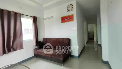 Cozy living room with brown sofa and wall art, natural light from window.