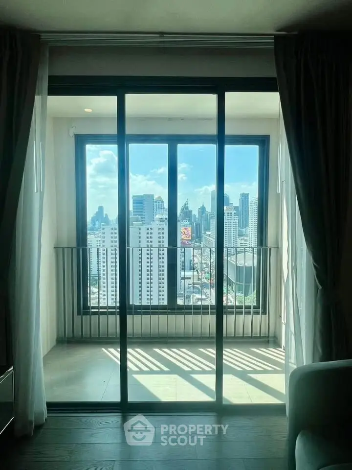 Stunning city view from modern apartment balcony with floor-to-ceiling windows.