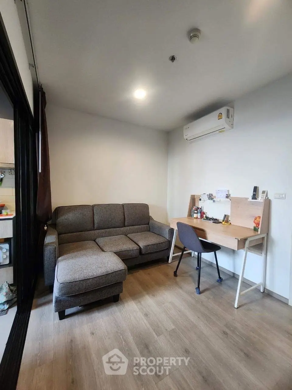 Modern living room with cozy sofa and study desk, perfect for urban living.