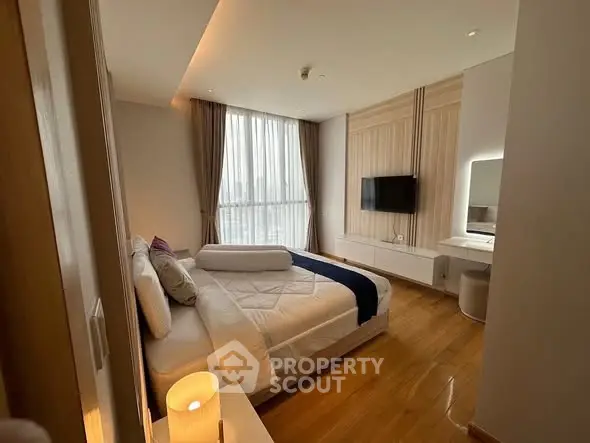 Luxurious bedroom with modern decor and large window offering natural light.