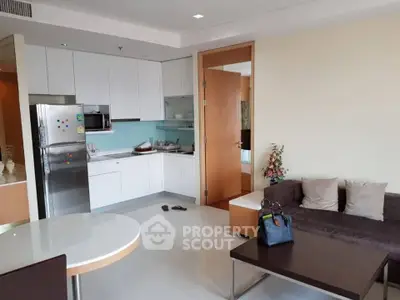 Modern open-layout kitchen and living room with sleek design and cozy seating area.