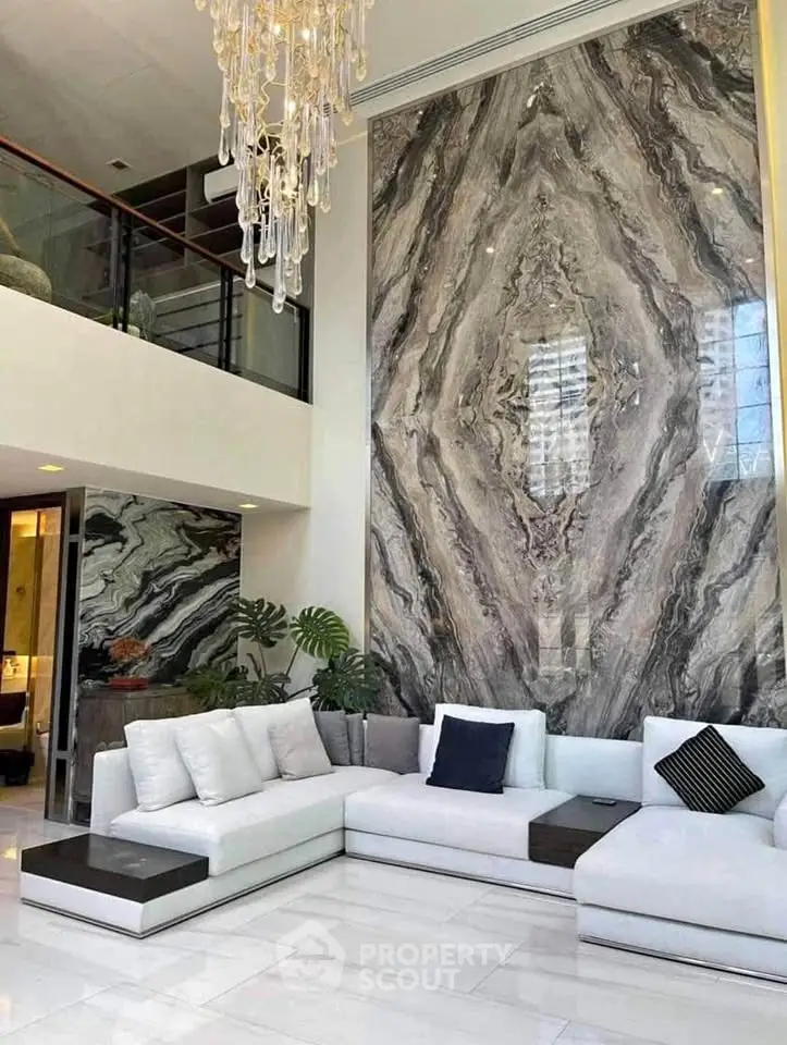 Luxurious living room with stunning marble feature wall and elegant chandelier