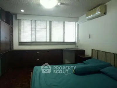 Spacious bedroom with built-in storage and air conditioning, perfect for comfort and convenience.