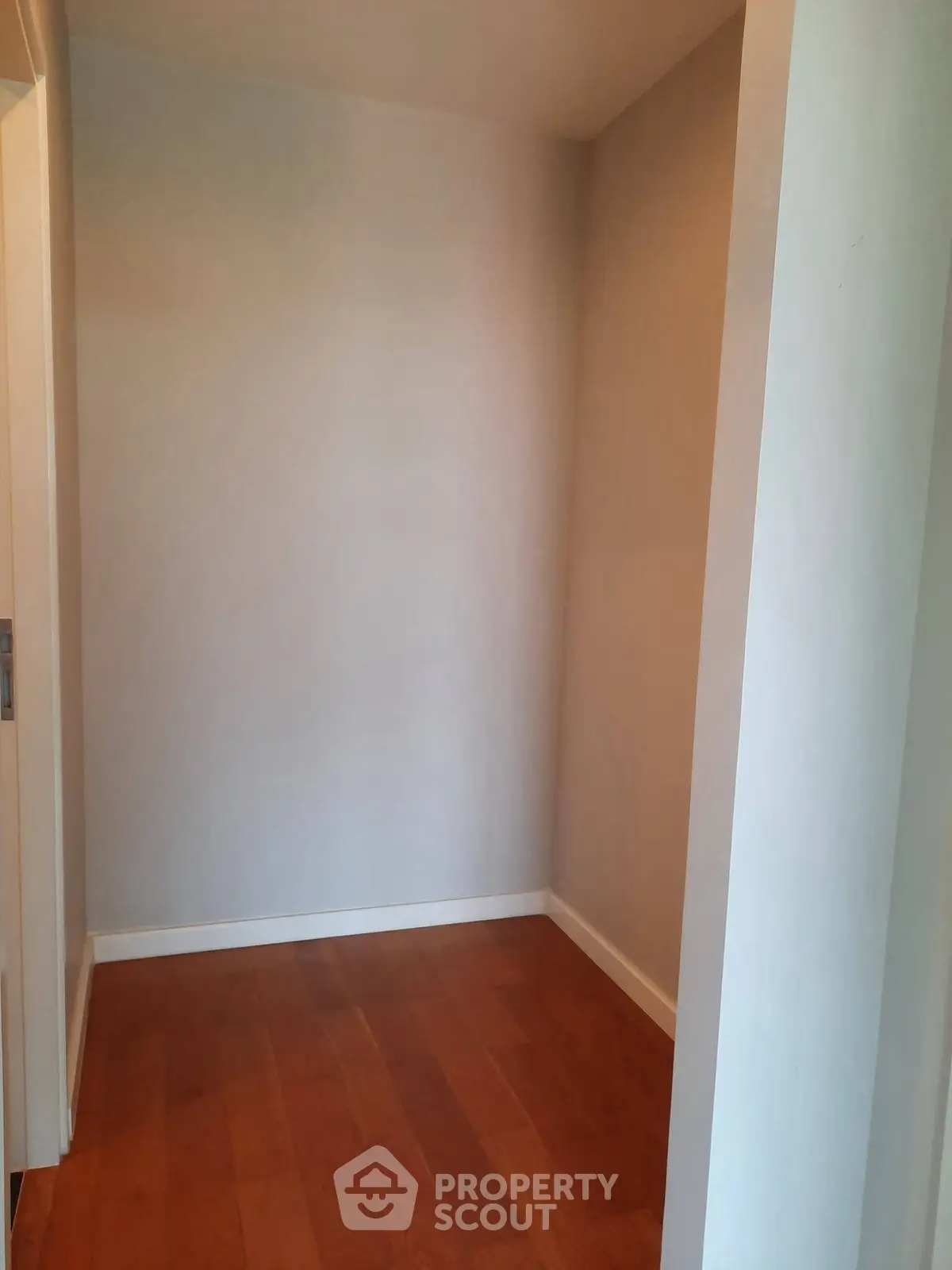 Cozy corner space with wooden flooring, perfect for storage or a small study nook.