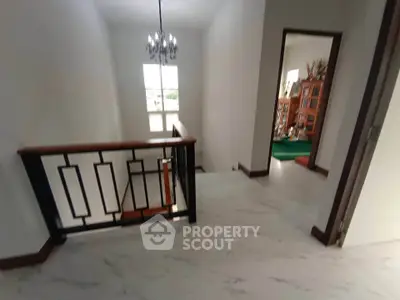 Spacious hallway with elegant chandelier and modern railing design