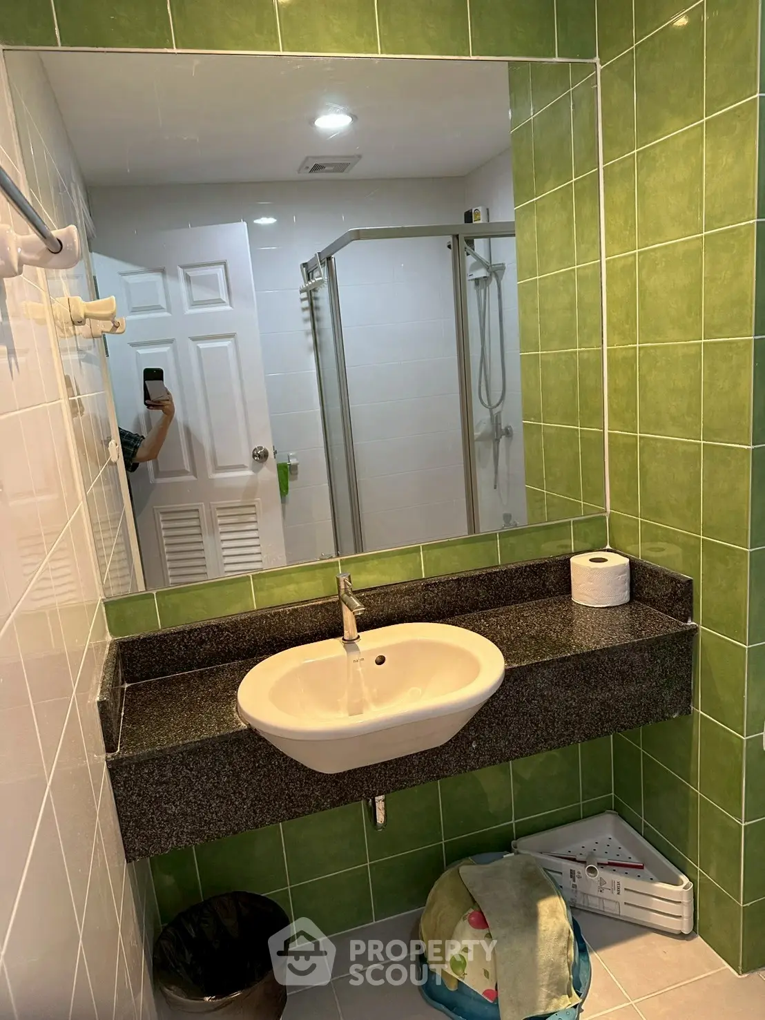 Modern bathroom with green tiles and glass shower enclosure