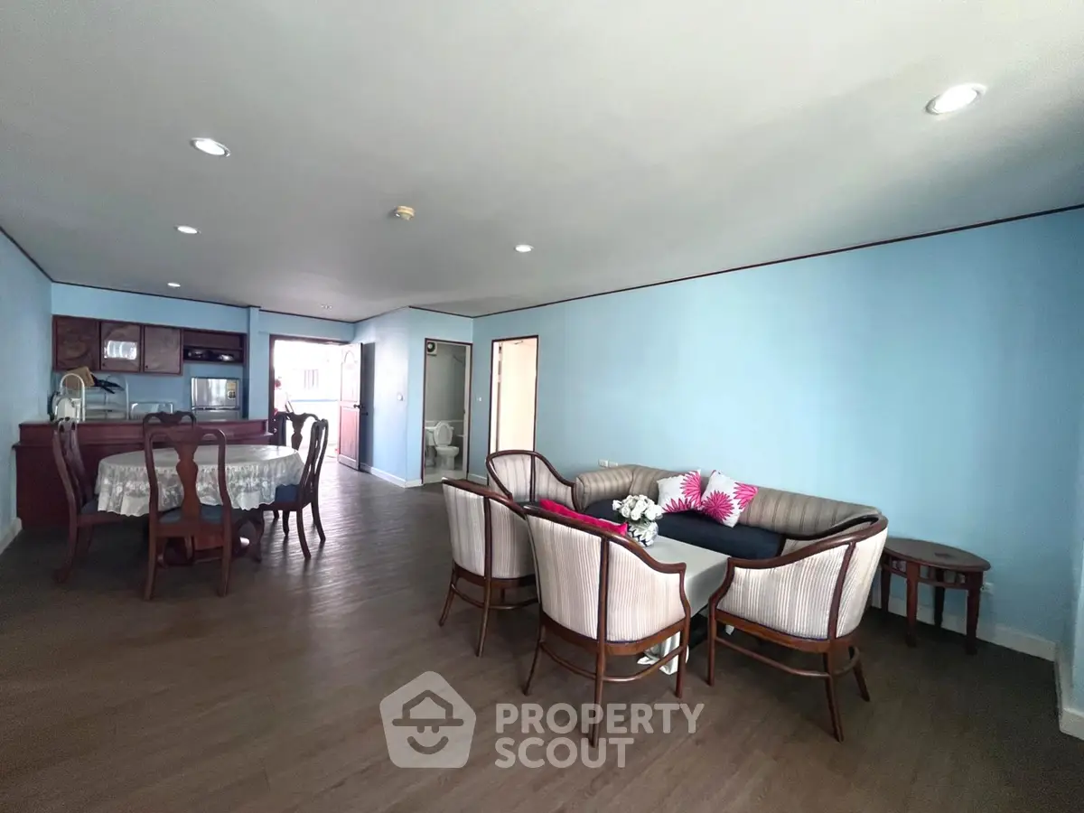 Spacious living room with elegant dining area and modern kitchen in open layout apartment.