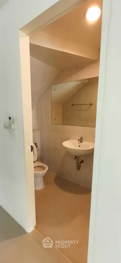 Compact bathroom with modern fixtures and under-sink storage in a cozy real estate unit.