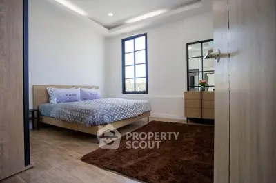 Modern bedroom with cozy decor and large window for natural light