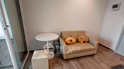 Cozy living room with modern sofa and round table, perfect for relaxation.