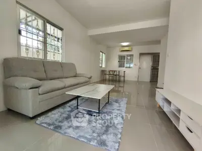 Spacious living room with modern sofa and sleek coffee table in a bright apartment.