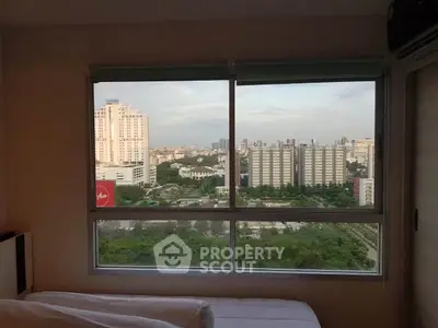 Stunning cityscape view from a modern bedroom window, showcasing urban skyline and lush greenery.
