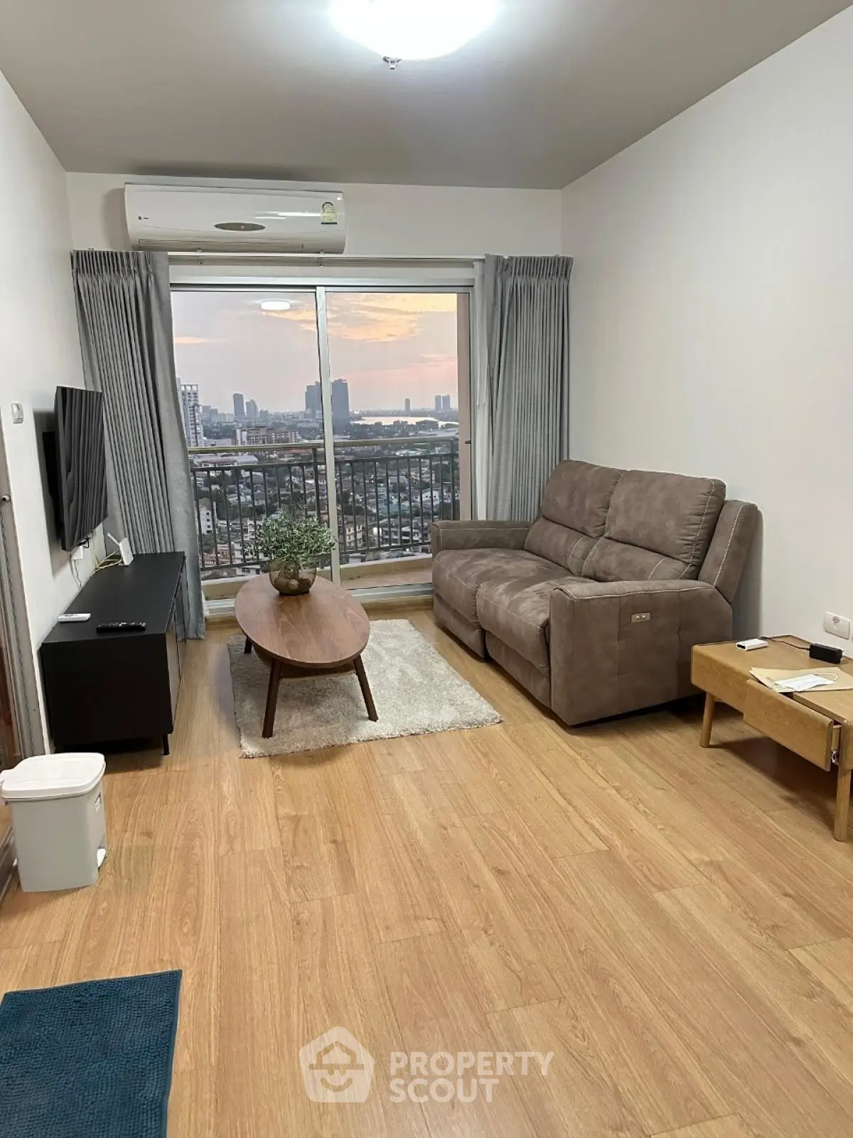 Modern living room with city view, featuring cozy sofa and stylish decor.