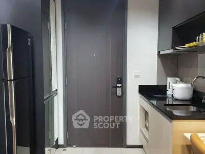 Modern kitchen with sleek appliances and stylish cabinetry in a contemporary apartment.