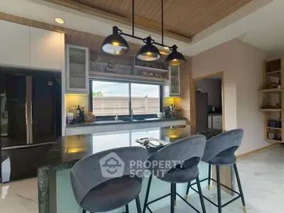 Modern kitchen with sleek design, featuring a large island and stylish lighting.