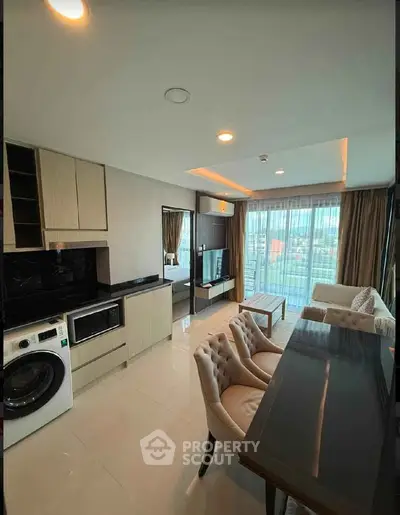 Modern open-plan living room with elegant furniture and large windows offering city views.
