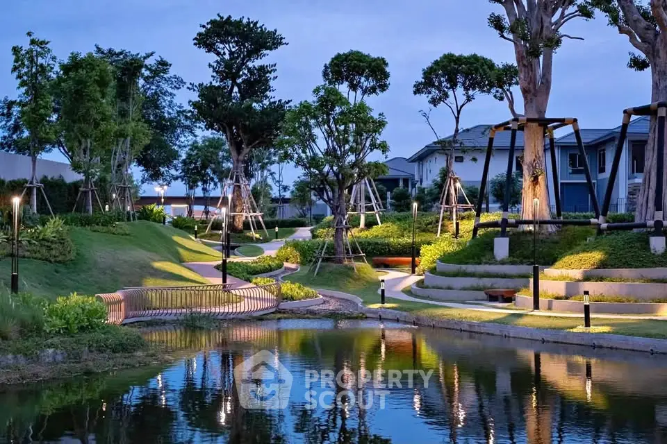 Stunning landscaped garden with serene pond and modern lighting in upscale residential area.