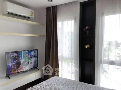 Modern bedroom with large windows, air conditioning, and wall-mounted TV, offering a cozy and bright atmosphere.