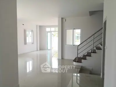 Spacious modern living room with sleek staircase and large windows
