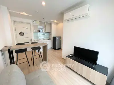 Modern living room with open kitchen, featuring sleek furniture and bright lighting.
