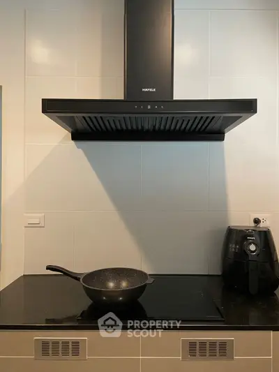 Modern kitchen with sleek black range hood and induction cooktop